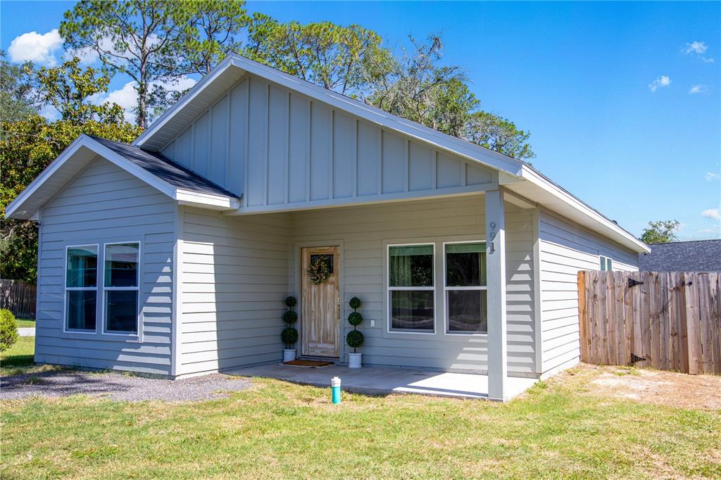 A light gray single-story house with a covered front porch and a wooden fence — 991 NW 3RD STREET, LAKE BUTLER, FL