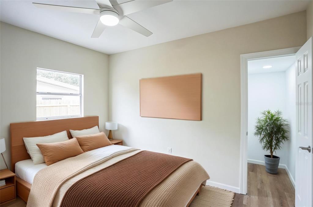 A bedroom features a bed with brown bedding, a ceiling fan, and an open doorway — 11357 116TH AVENUE, LARGO, FL
