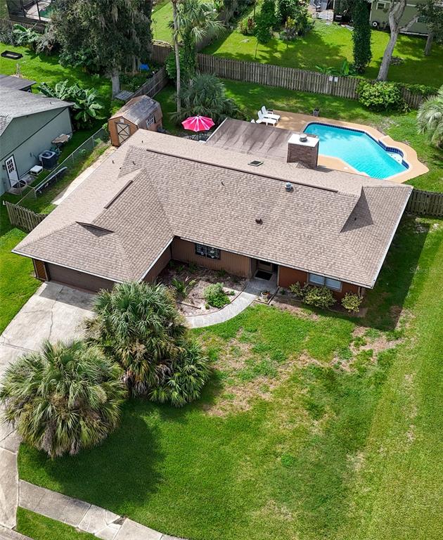 An aerial view shows a single-story house with a brown roof, pool, and palm trees — 608 TOUCHSTONE CIRCLE, PORT ORANGE, FL