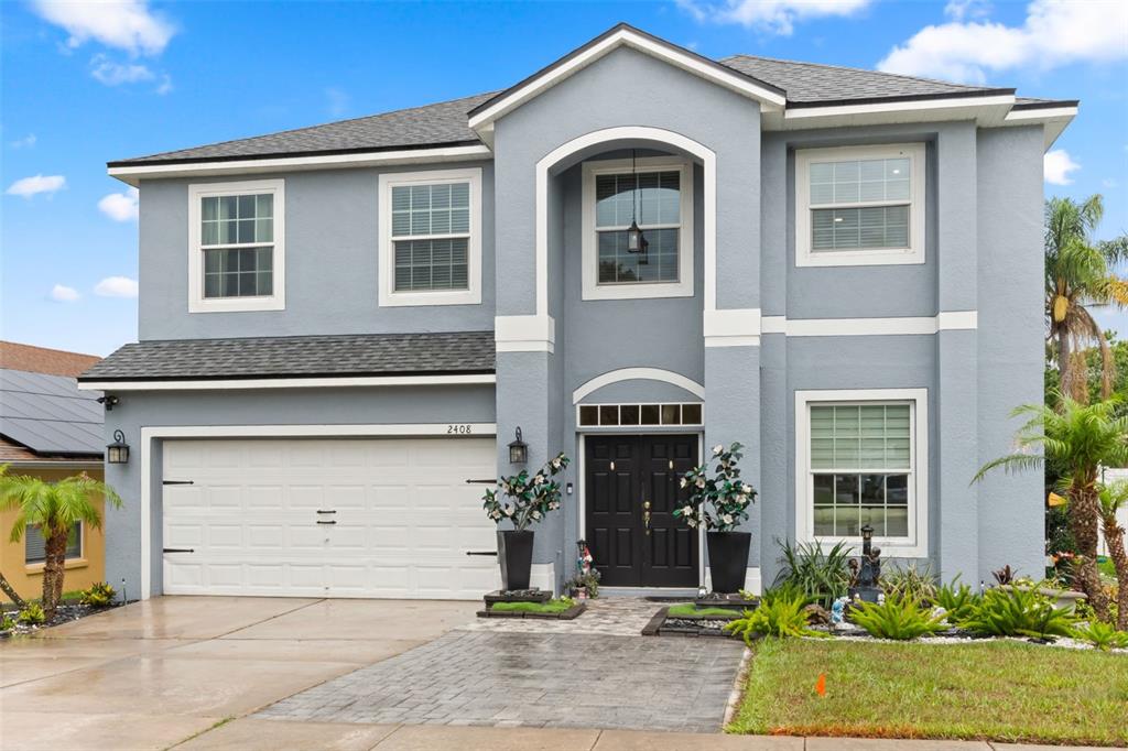 A two-story blue house with a white-trimmed arched entryway and a two-car garage — 2408 CIMMARON ASH WAY, APOPKA, FL