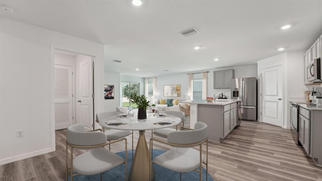 A dining area with a round table and chairs opens into a kitchen and living room — 4330 HIDDEN FARM DRIVE, PLANT CITY, FL