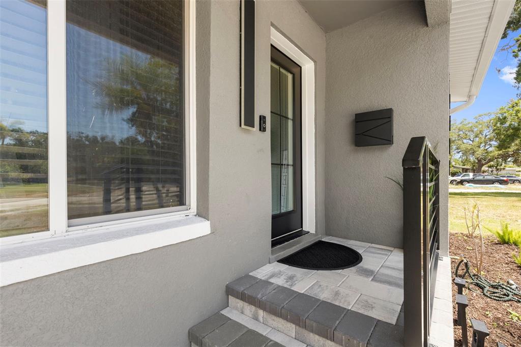 A single-story gray house with a concrete driveway and a white fence at sunset — 4832 5TH STREET S, ST PETERSBURG, FL