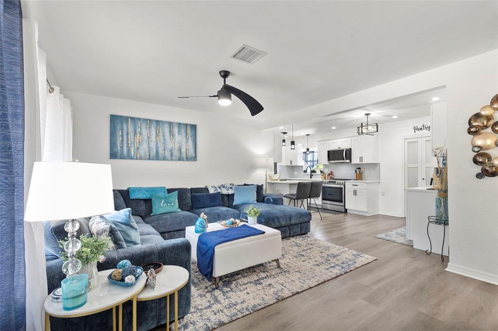 A gray house exterior features a front porch with two chairs, a table, and stairs — 4832 5TH STREET S, ST PETERSBURG, FL