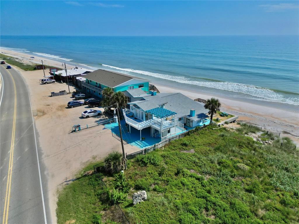 An aerial view shows a beachside house with a blue deck next to the ocean — 2815 S OCEAN SHORE BOULEVARD, FLAGLER BEACH, FL