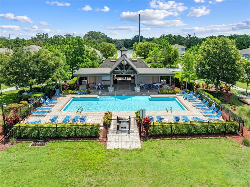 An aerial view of a rectangular swimming pool surrounded by lounge chairs and a pavilion — 1619 REFLECTION COVE, ST CLOUD, FL