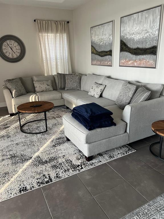A bedroom features a king-sized bed with a blue striped quilt and a sailboat painting — 209 MACAULAYS COVE, HAINES CITY, FL