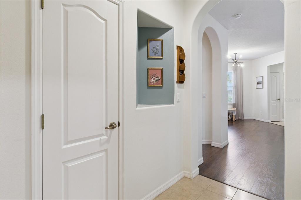 A hallway with a white door, a blue recessed wall niche, and an arched entryway — 907 OCASO LANE UNIT 101, ROCKLEDGE, FL