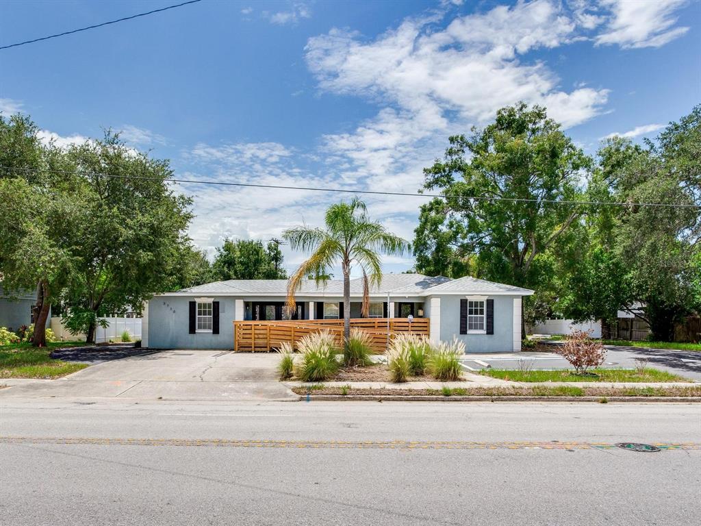 A single-story house with a light blue exterior, black shutters, and a wooden ramp entrance — 3710 W AZEELE STREET, TAMPA, FL