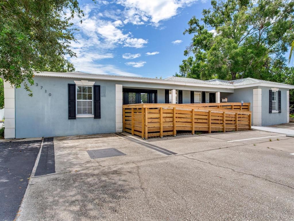 A single-story building with a light blue exterior features a wooden wheelchair ramp and parking — 3710 W AZEELE STREET, TAMPA, FL