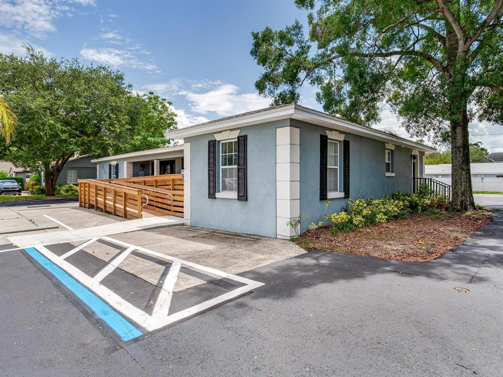 A blue single-story building features a wooden wheelchair ramp and a marked handicap parking space — 3710 W AZEELE STREET, TAMPA, FL