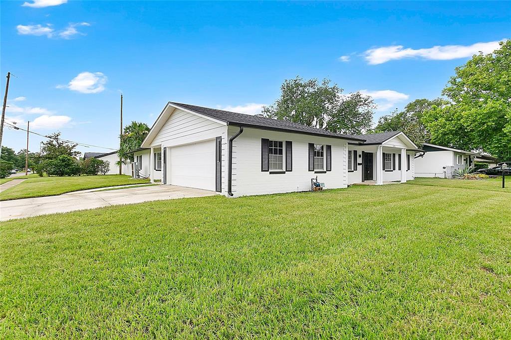 A white, single-story ranch-style house with a two-car garage and a large front lawn — 2494 CASTLEWOOD ROAD, MAITLAND, FL
