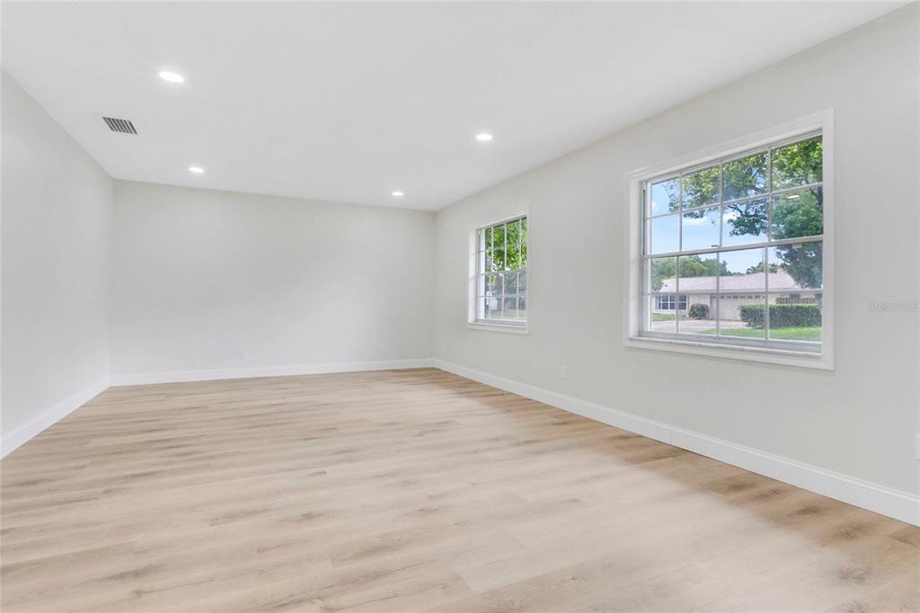 An empty room with light-colored walls, wood-look flooring, recessed lighting, and two windows — 2494 CASTLEWOOD ROAD, MAITLAND, FL