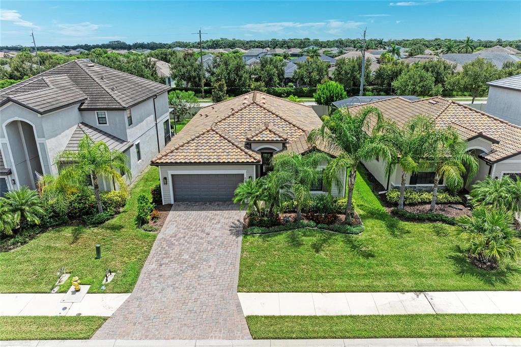 A single-story house with a paved driveway, a two-car garage, and palm trees in front — 621 FIRE BUSH COURT, BRADENTON, FL