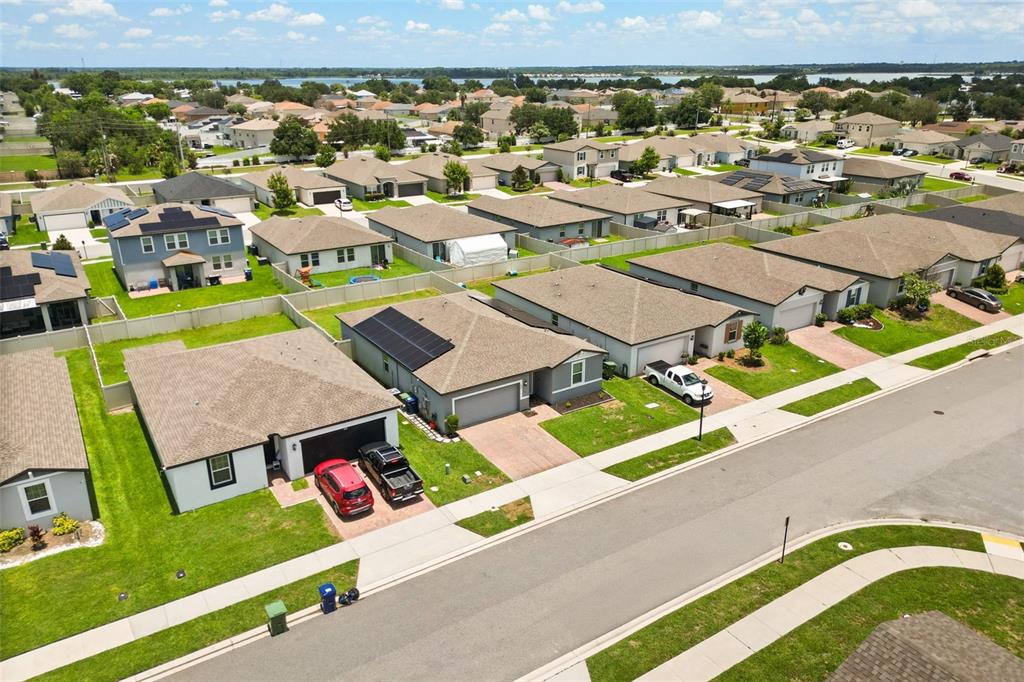 An aerial view of a suburban neighborhood featuring single-family homes with driveways and solar panels — 428 MCKENNA DRIVE, WINTER HAVEN, FL