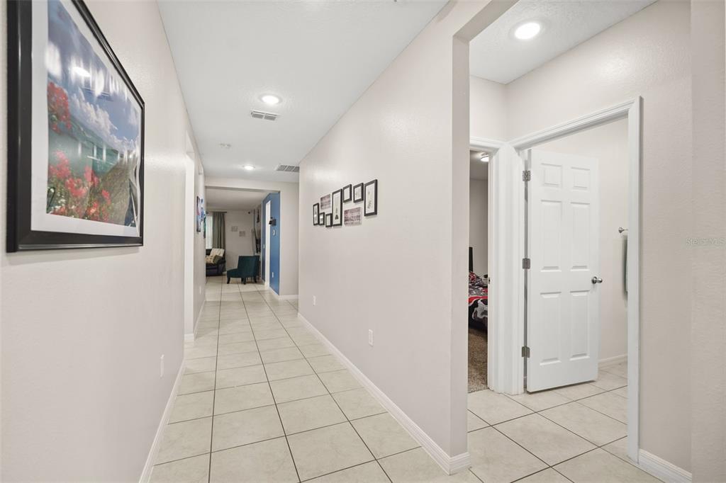 A tiled hallway leads to a living area with a bedroom door on the right — 428 MCKENNA DRIVE, WINTER HAVEN, FL
