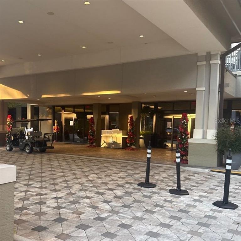 A covered building entrance features a paved driveway, a golf cart, and holiday decorations — 14501 GROVE RESORT AVENUE UNIT 2528, WINTER GARDEN, FL