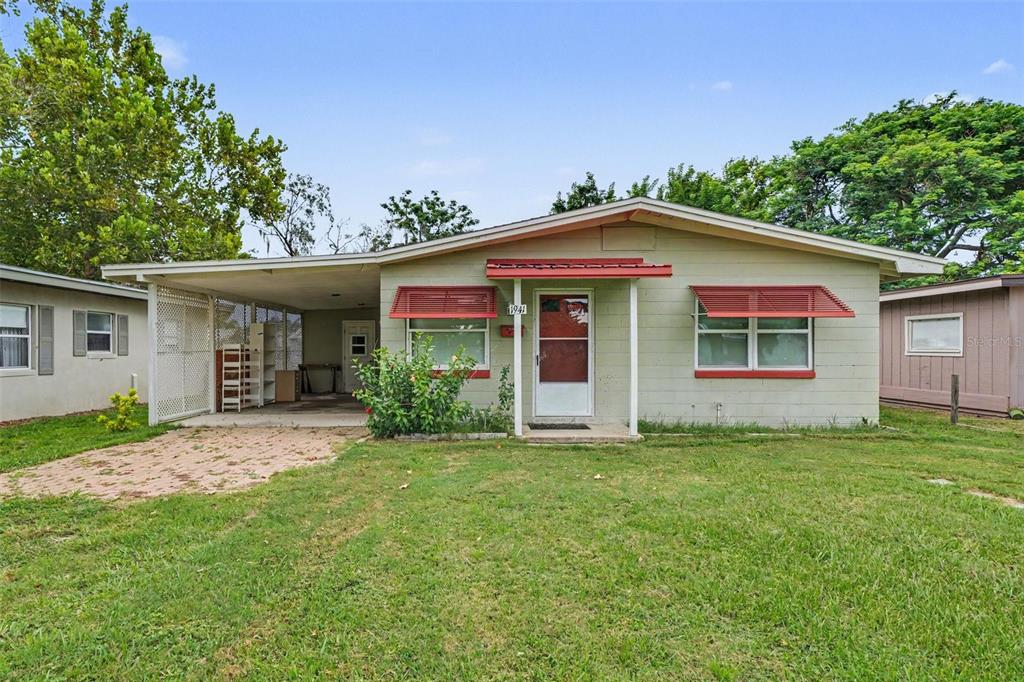 A single-story house with a carport, light green siding, and red window awnings — 1941 OGLESBY AVENUE, WINTER PARK, FL