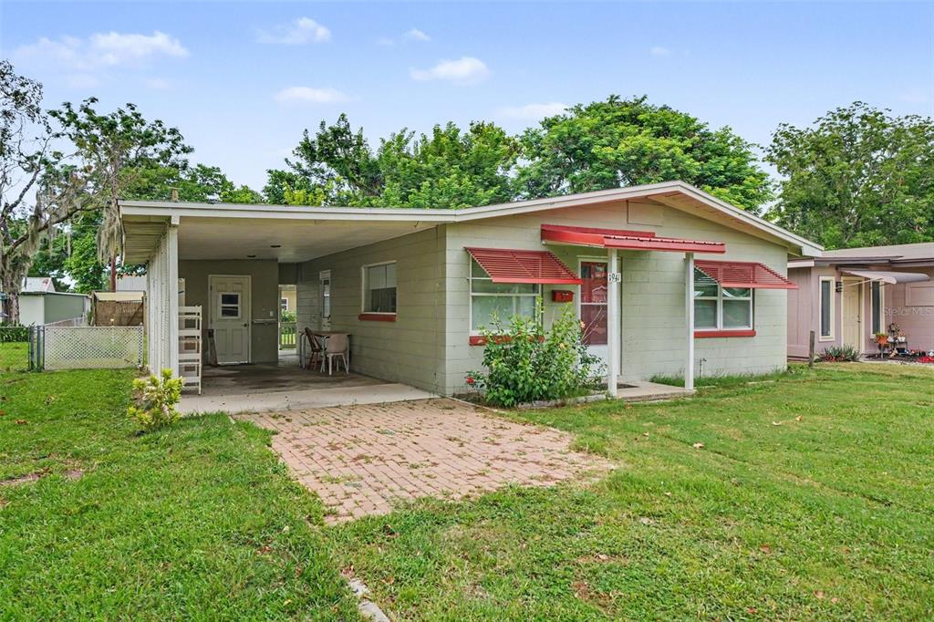 A single-story house with a light green exterior, a carport, and red window awnings — 1941 OGLESBY AVENUE, WINTER PARK, FL