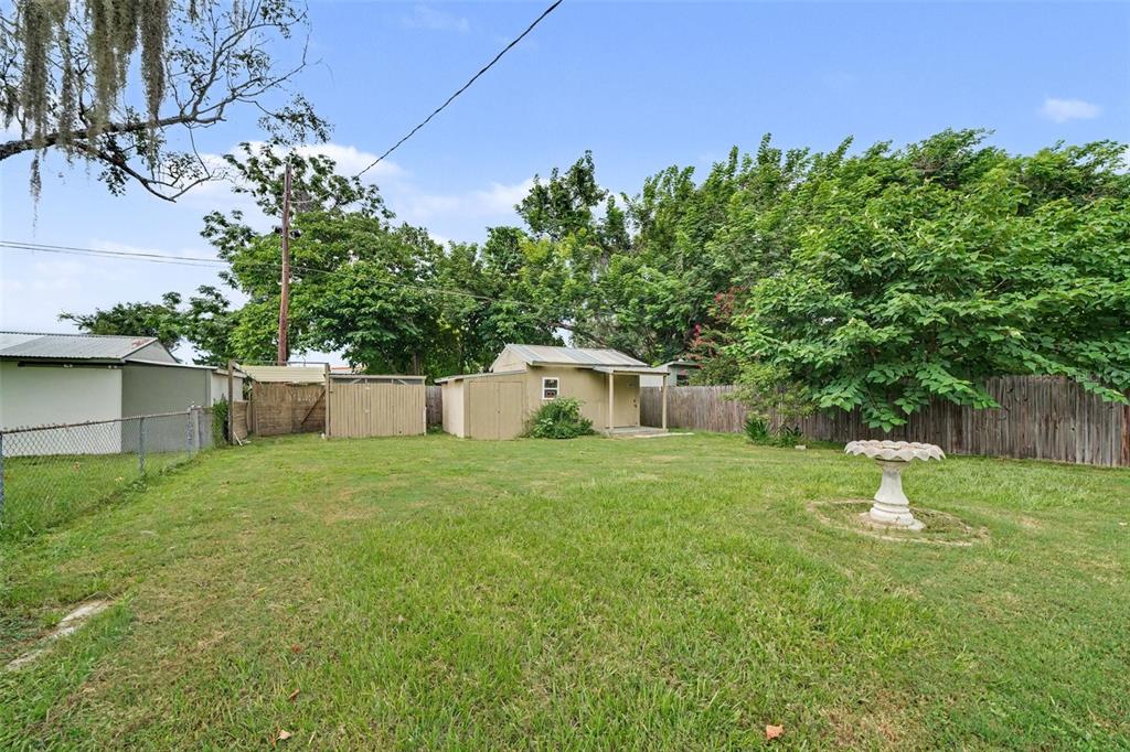 A grassy backyard features a small shed, a birdbath, and a wooden fence — 1941 OGLESBY AVENUE, WINTER PARK, FL