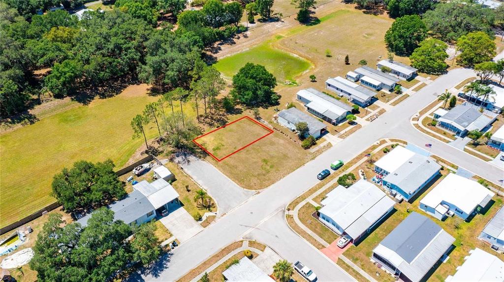 An aerial view shows a vacant rectangular lot outlined in red within a residential neighborhood — CHRIS DR., WESLEY CHAPEL, FL