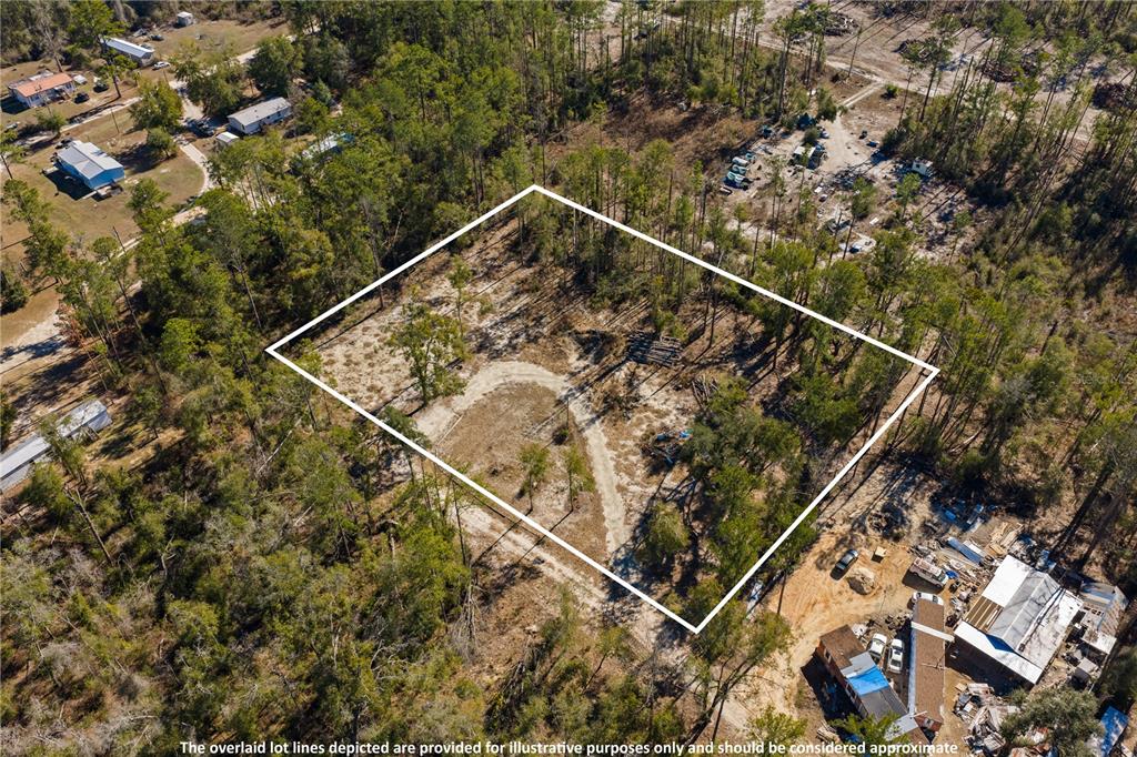 An aerial view shows a rectangular, wooded vacant lot with a dirt driveway — 12TH TERRACE, LIVE OAK, FL