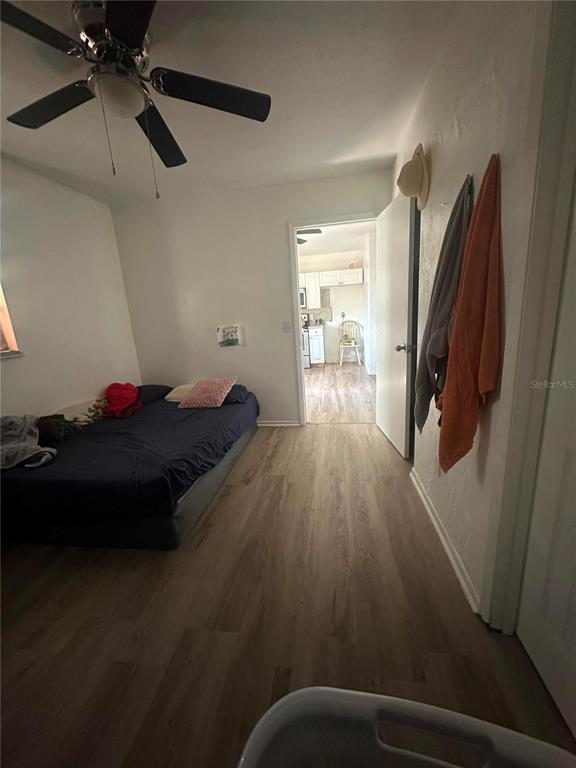 A bedroom features wood-look flooring, a ceiling fan, and a doorway leading to a kitchen — 1836 SW HARLEM CIRCLE, ARCADIA, FL