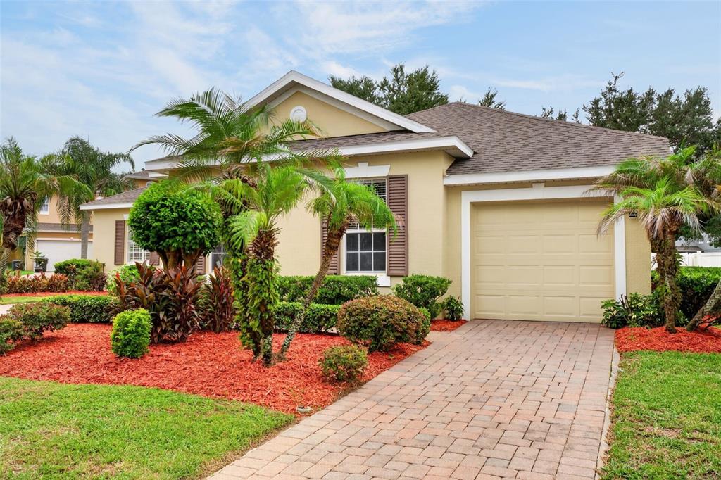A single-story house with a tan exterior, a paved driveway, and a front-facing garage — 2623 PALASTRO WAY, OCOEE, FL