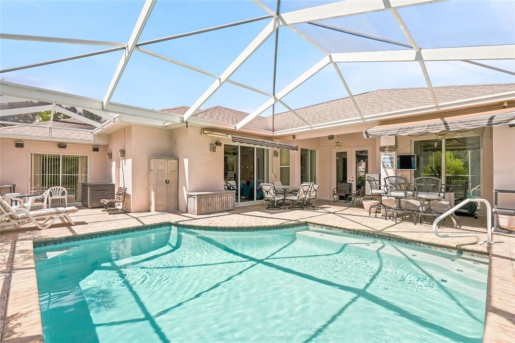 A screened-in patio features a swimming pool, outdoor furniture, and sliding glass doors — 8206 NIGHTINGALE ROAD, WEEKI WACHEE, FL
