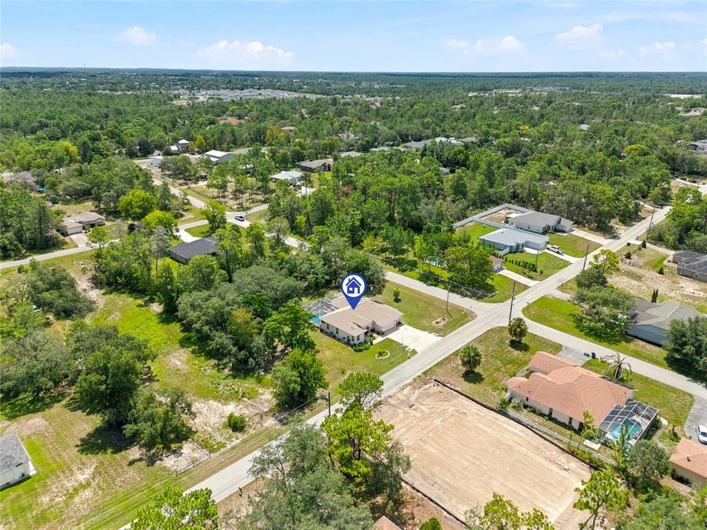 An aerial view shows a residential house with a pool in a wooded neighborhood — 8206 NIGHTINGALE ROAD, WEEKI WACHEE, FL