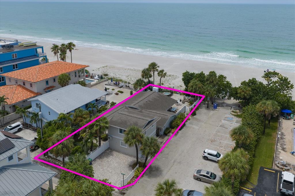 A two-story house with a two-car garage and a sandy driveway under a blue sky — 2308 BEACH TRAIL, INDIAN ROCKS BEACH, FL