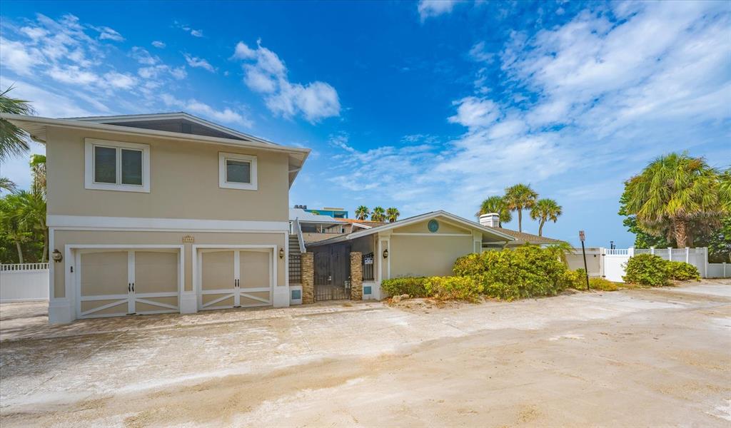 An aerial view of a beach with multi-story residential buildings and a pink arrow pointing down — 2308 BEACH TRAIL, INDIAN ROCKS BEACH, FL