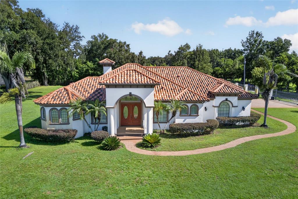 A single-story stucco house with a terracotta tile roof and a central arched entryway — 301 PRUETT ROAD, SEFFNER, FL