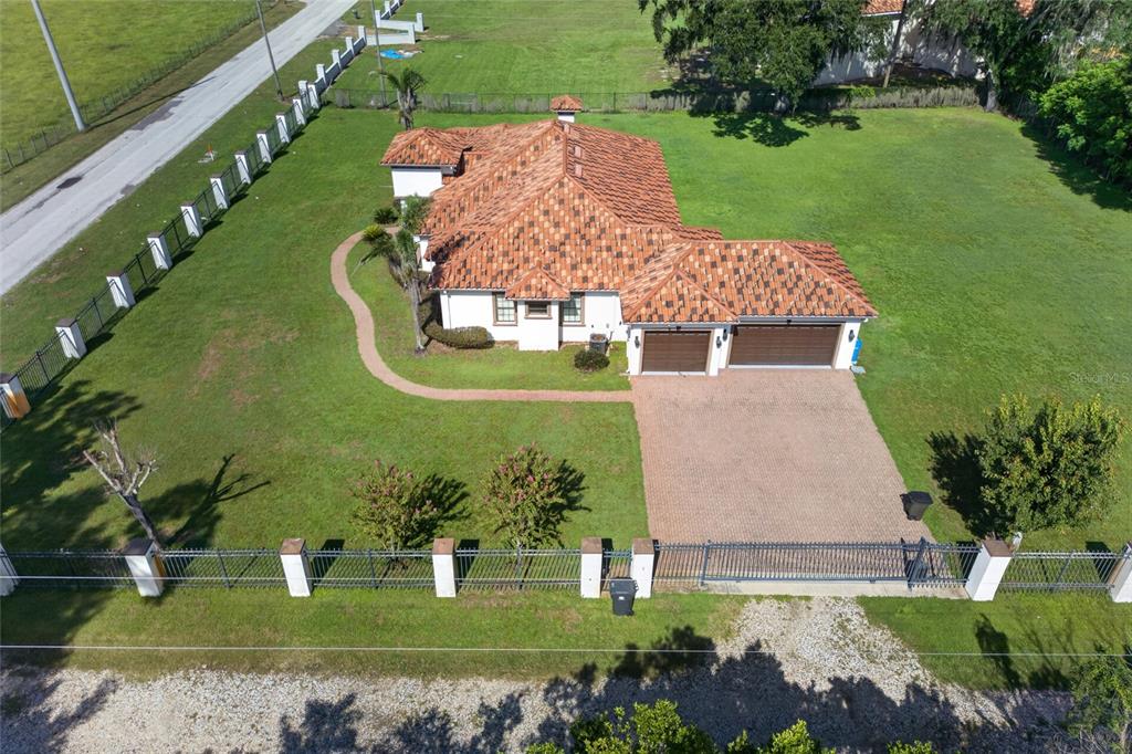 An aerial view of a single-story house with a tiled roof and a gated driveway — 301 PRUETT ROAD, SEFFNER, FL
