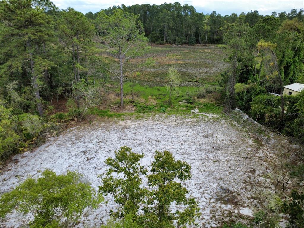 An elevated view of a sandy, cleared lot bordered by trees and a marshy area — VIOLA AVENUE, EUSTIS, FL