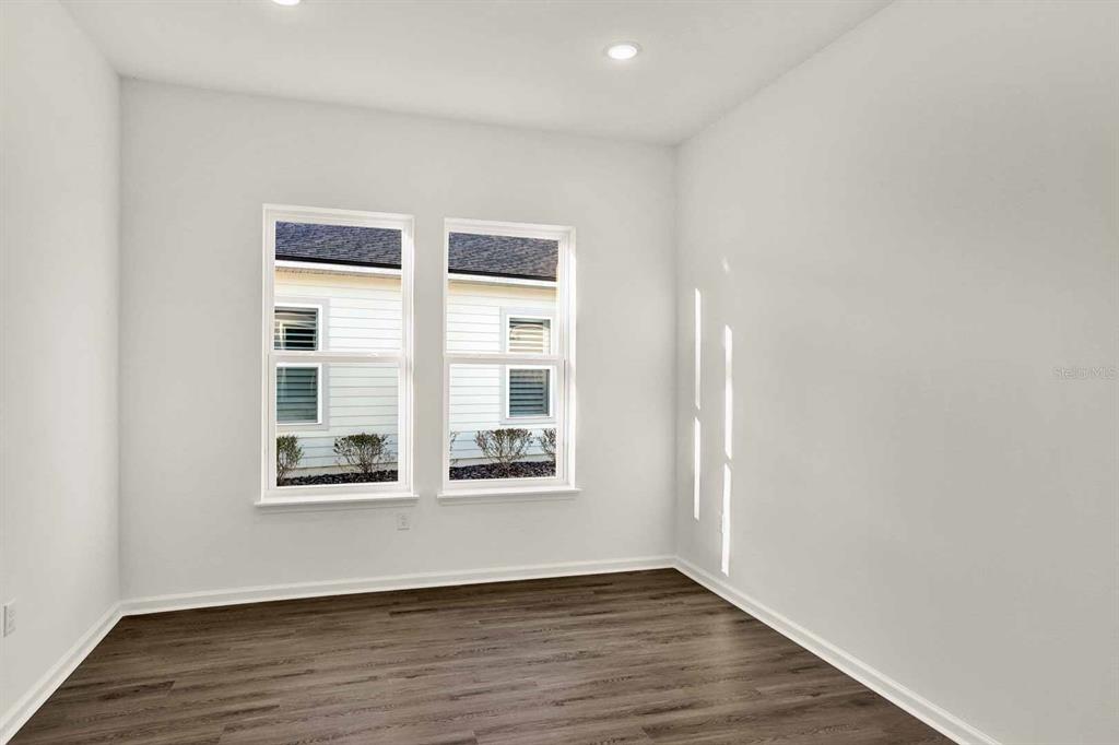 An empty room with white walls, recessed lighting, and dark wood-look flooring — 32 WINTERFIELD PLACE, ST AUGUSTINE, FL