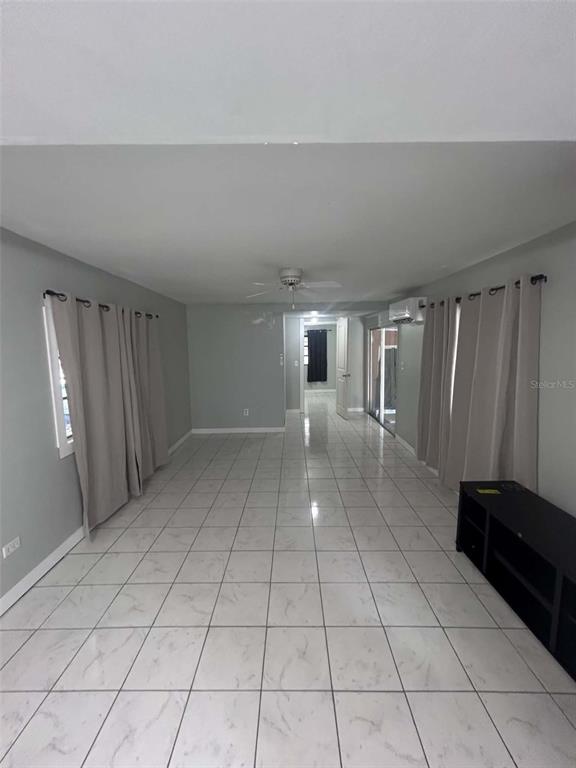 A living room features light gray walls, white tiled floors, and floor-to-ceiling curtains — 2650 SW 54TH PLACE, FORT LAUDERDALE, FL