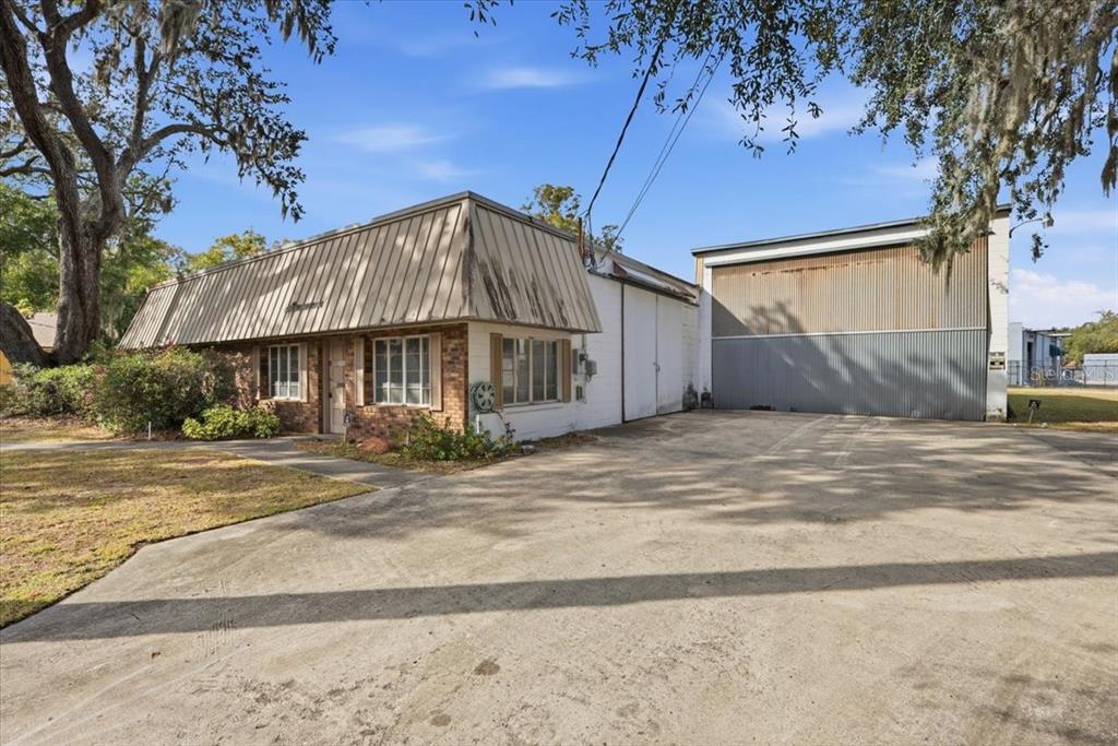 A single-story commercial building with a brick facade and an attached metal warehouse bay — 1022 WILFRED DRIVE UNIT SEALED BID!, ORLANDO, FL