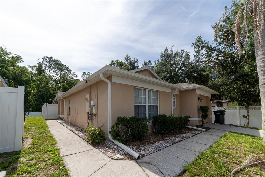 A tan single-story house with a garage, white trim, and a concrete walkway in front — 298 HAMMOCK COURT, DAVENPORT, FL