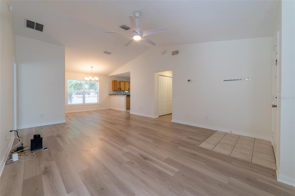 A dining area features light wood-look flooring, a window with blinds, and a chandelier — 298 HAMMOCK COURT, DAVENPORT, FL