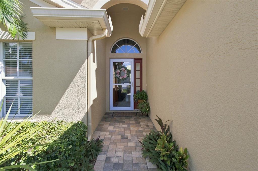 An aerial view of a tan single-story house with a two-car garage and palm trees — 23737 ESTERO COURT, LAND O LAKES, FL