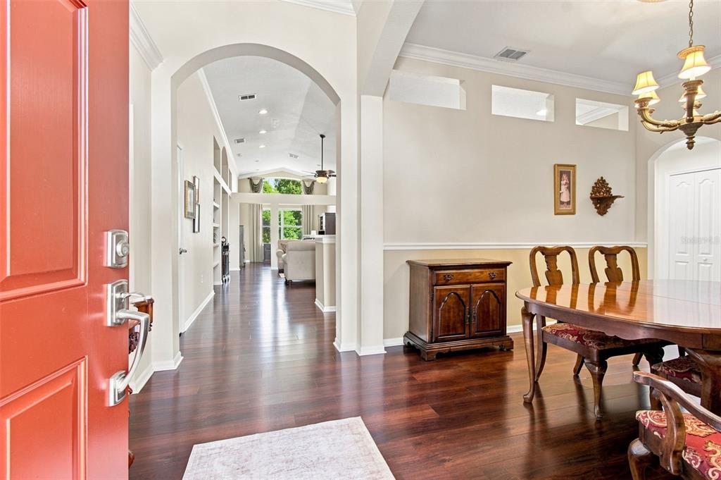 A paved walkway leads to a front door with a storm door and arched transom window — 23737 ESTERO COURT, LAND O LAKES, FL