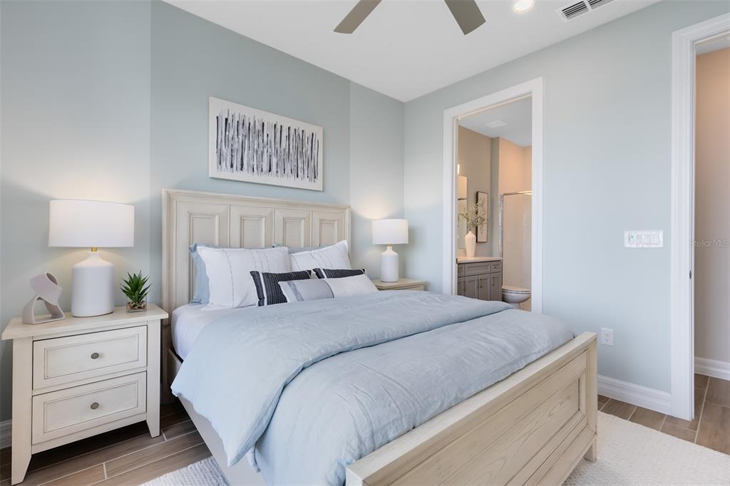 A bedroom features a light wood bed frame, matching nightstands, and a light blue wall — 5249 HANDSOME HILLS DRIVE, MOUNT DORA, FL