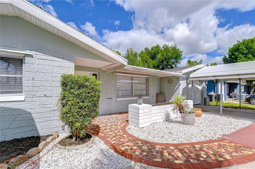 A single-story house features two metal carports and a white gravel front yard — 10901 OLDHAM ROAD, PORT RICHEY, FL