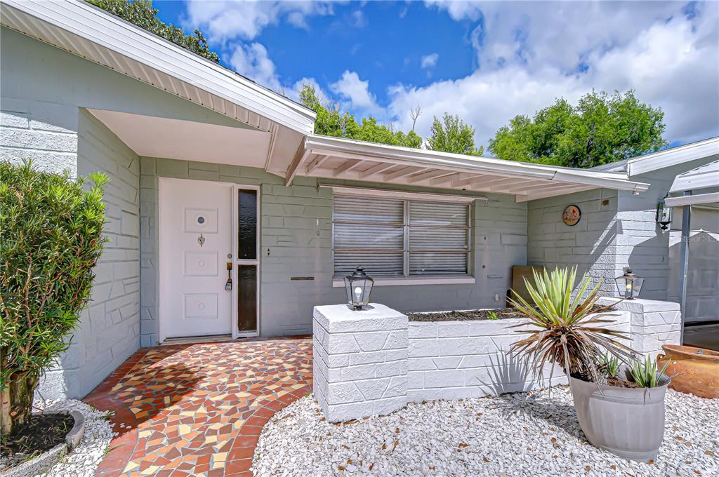A metal carport stands over a concrete driveway in front of a single-story house — 10901 OLDHAM ROAD, PORT RICHEY, FL