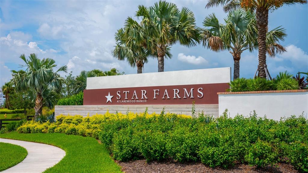 A monument sign for Star Farms at Lakewood Ranch sits behind landscaped bushes and palm trees — 3834 BUTTE TRAIL, LAKEWOOD RANCH, FL