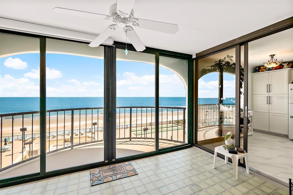 A sunroom with tile flooring and a ceiling fan overlooks a beach and the ocean — 3003 S ATLANTIC AVENUE UNIT 4C5, DAYTONA BEACH SHORES, FL