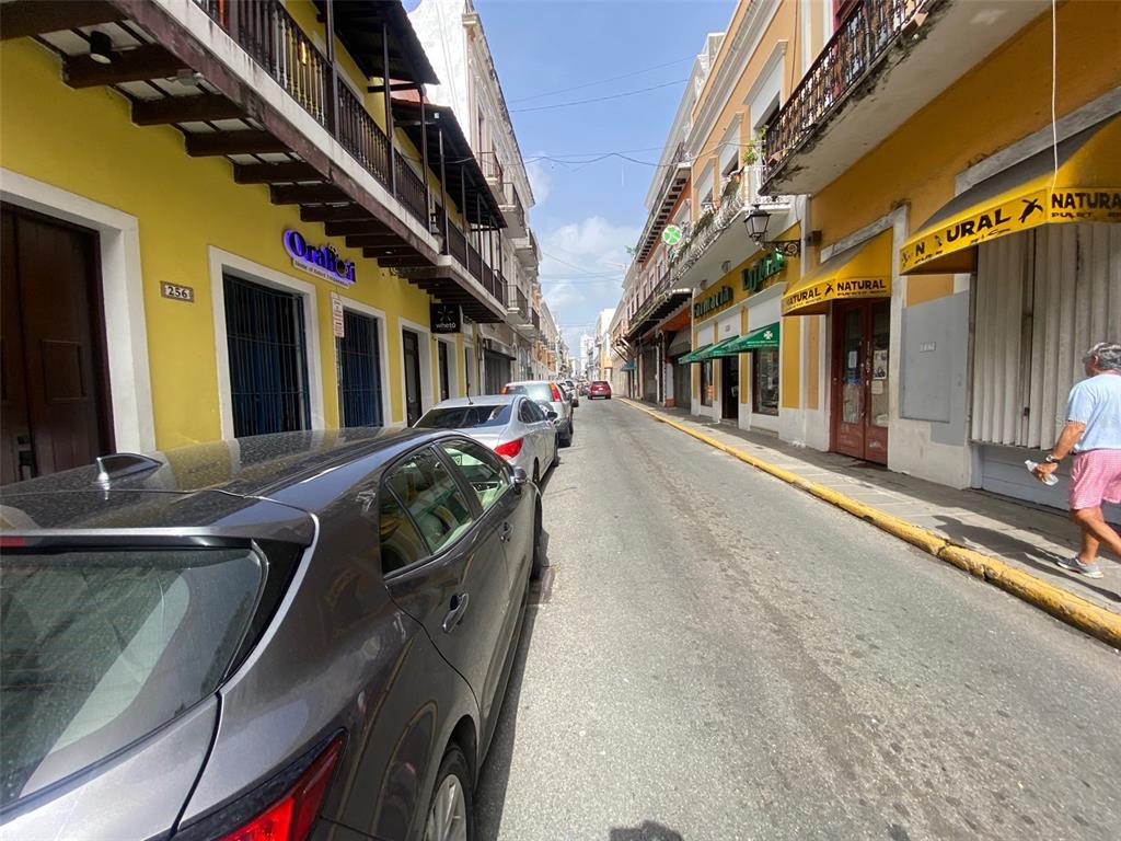 A narrow street in Old San Juan features colorful colonial buildings and parked cars — 257 SAN FRANCISCO, SAN JUAN, PR