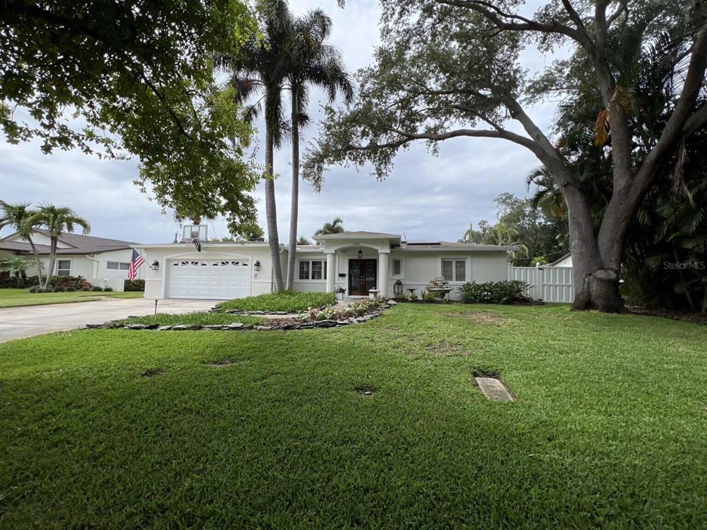A single-story house with a white exterior, a two-car garage, and a large front lawn — 146 GIRALDA BOULEVARD NE, ST PETERSBURG, FL