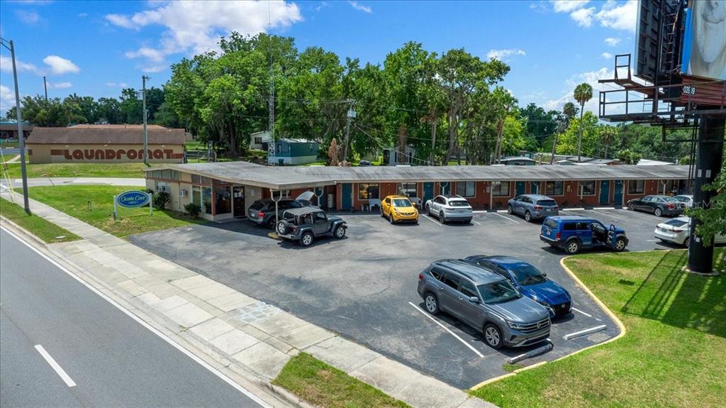 An aerial view shows a single-story motel building with a parking lot and billboard — 2210 S PINE AVENUE, OCALA, FL