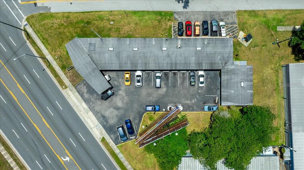 Aerial view of a commercial building with a parking lot and adjacent road — 2210 S PINE AVENUE, OCALA, FL